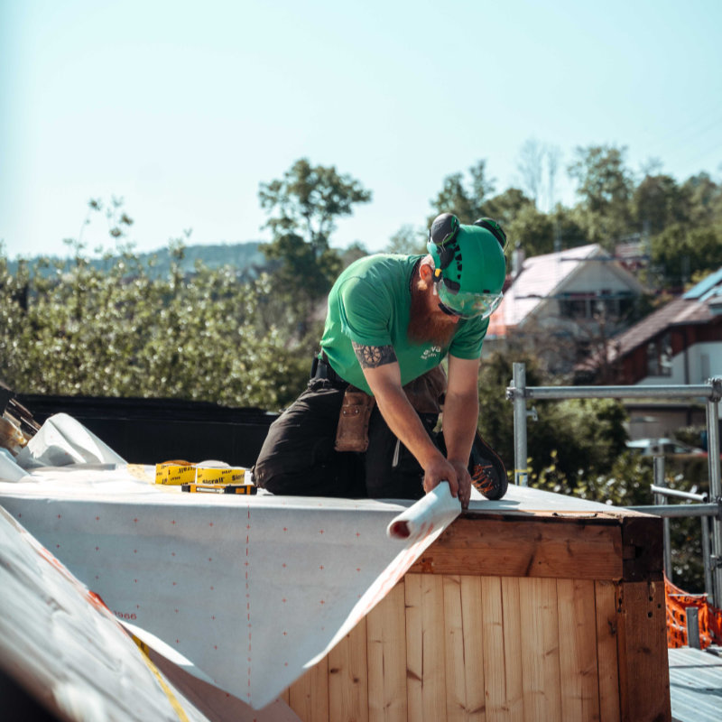 Lernender Dachdecker bei der Arbeit auf einem Dach